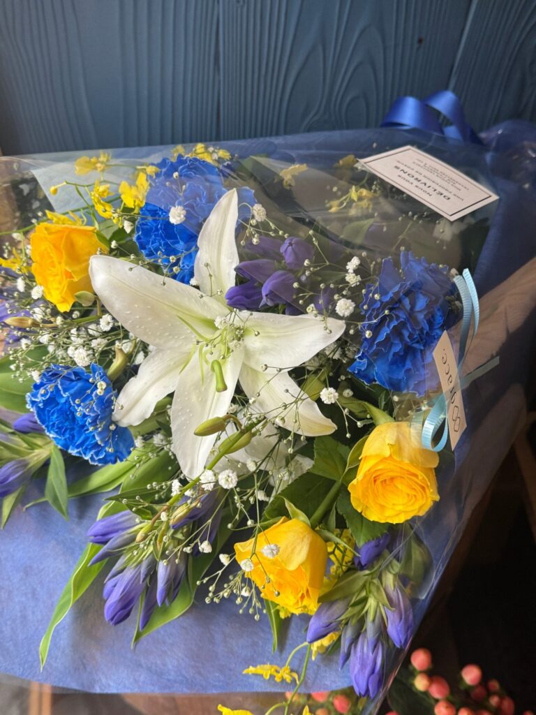 白いユリと青・黄色の花束